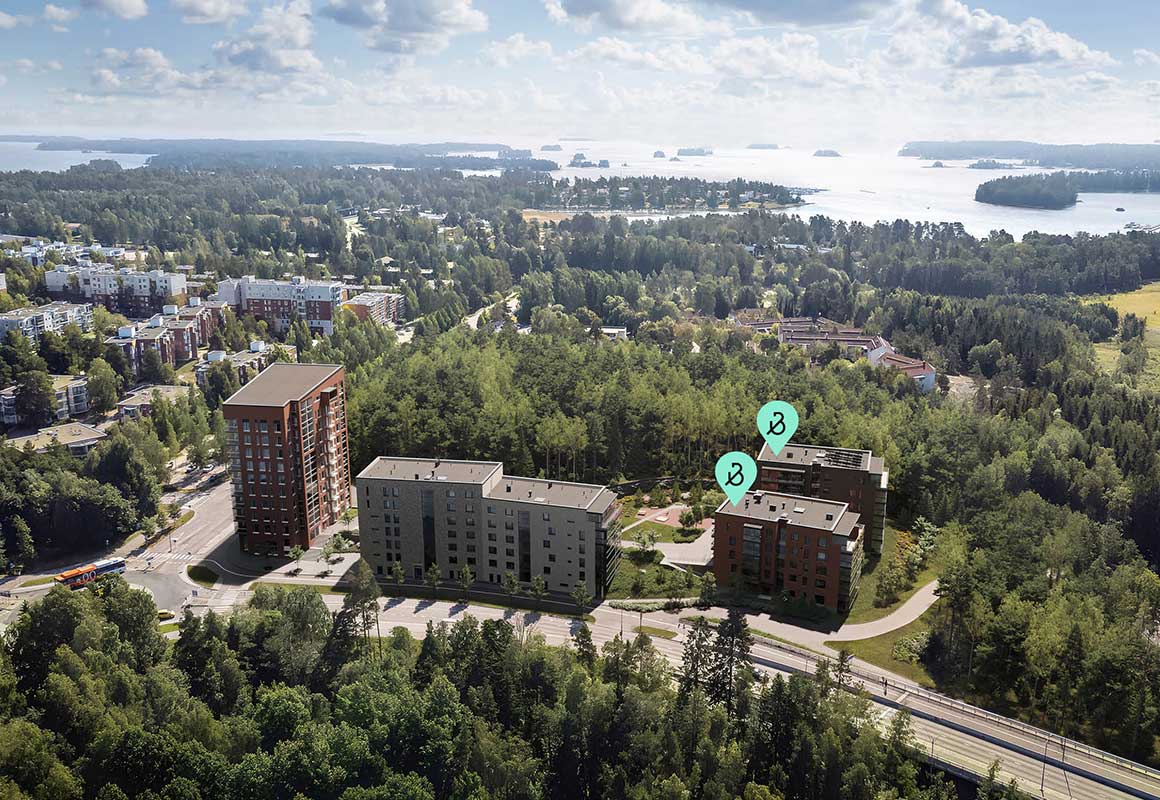 Ilmakuva Espoon Tiirasta, jossa Bonavan asuinkerrostalot sijaitsevat vehreän metsän reunalla lähellä merenrantaa.