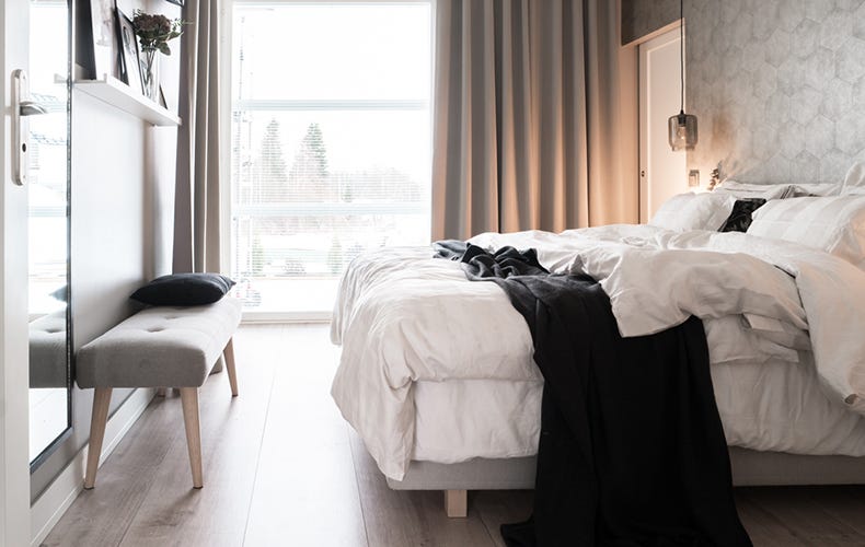 Makuuhuoneessa muhkeat, koko ikkunaseinän levyiset pimentävät verhot.