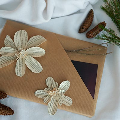 Lukutoukan paketti on koristeltu vanhan kirjan sivusta leikatulla kukalla.