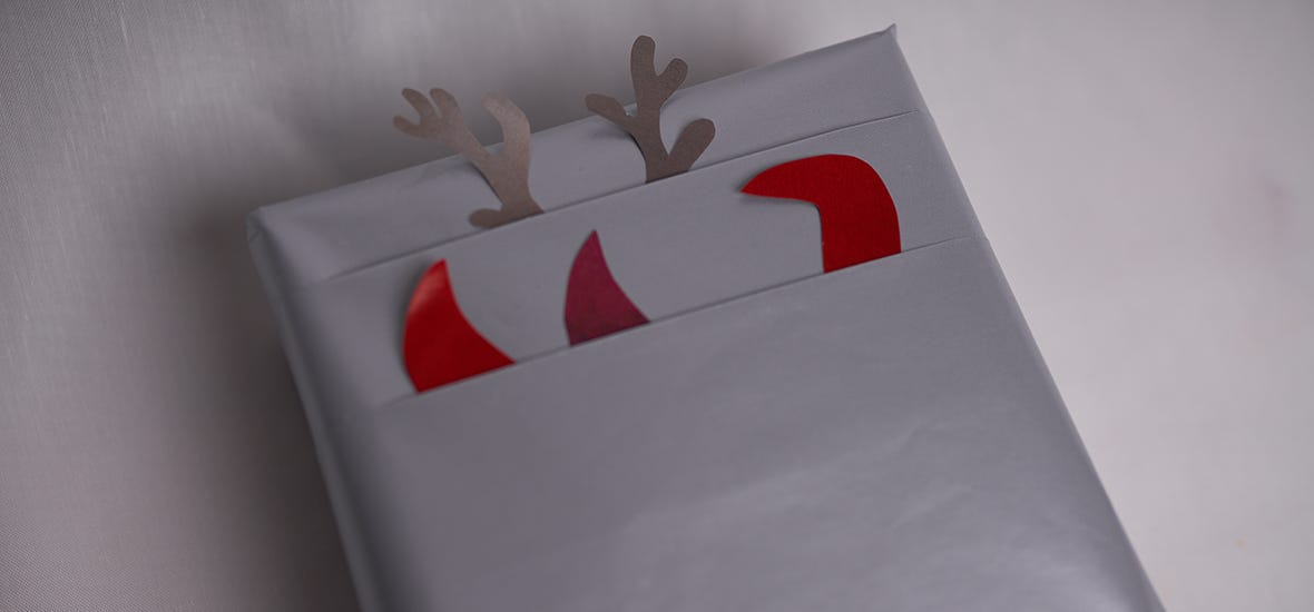 Paperin taitoksista kurkkivat tontut ja poro on leikattu sisustuslehden sivuista.