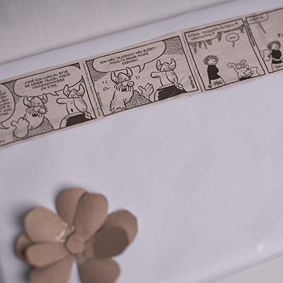 Sarjakuvista luotu koristenauha kiertää paketin ympäri.