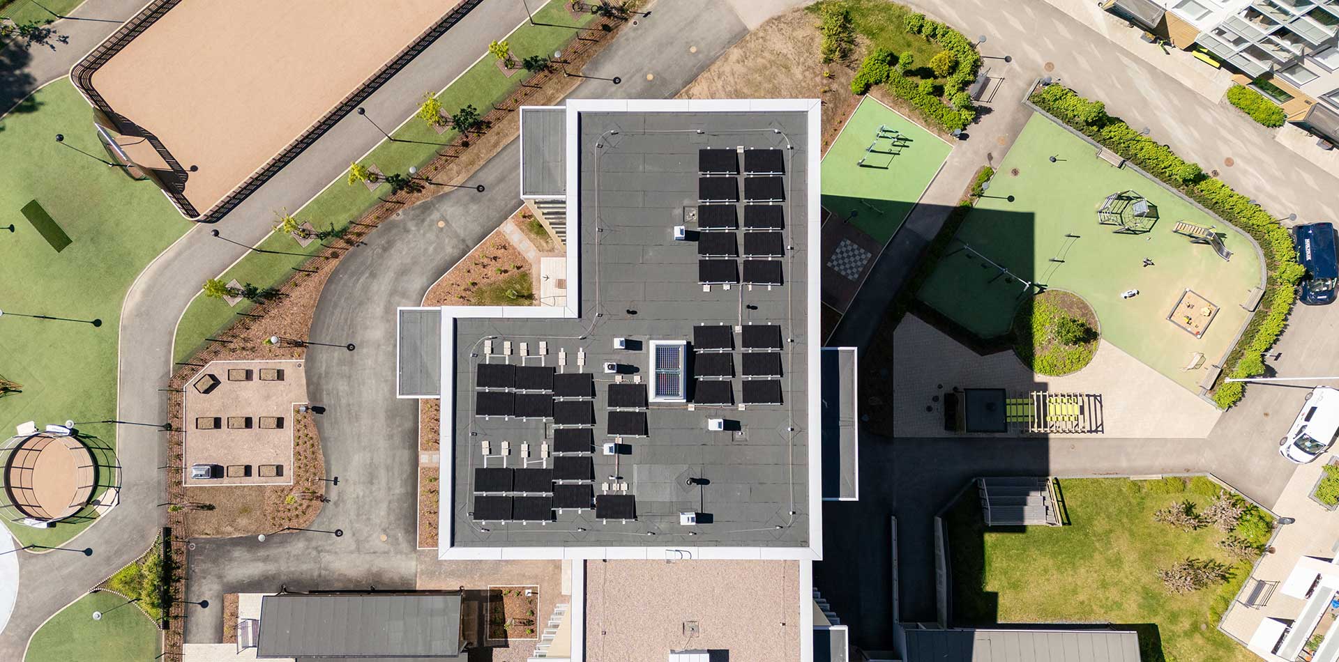 Ylhäältä kuvattu kerrostalon katto Tampereen Tuikkeessa, jossa aurinkopaneelit muodostavat energiayhteisön perustan.
