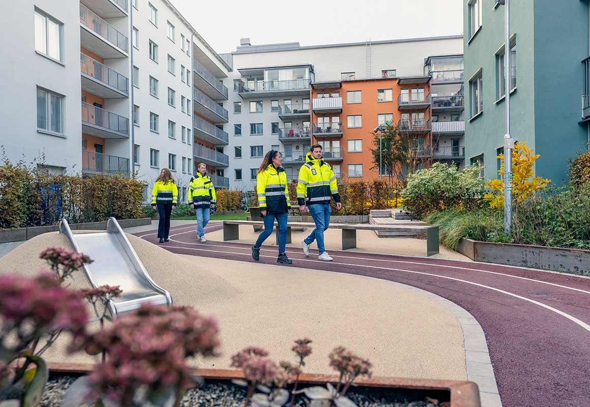 Bonavan työntekijöitä kävelemässä uudella asuinalueella kerrostalojen pihapiirissä.