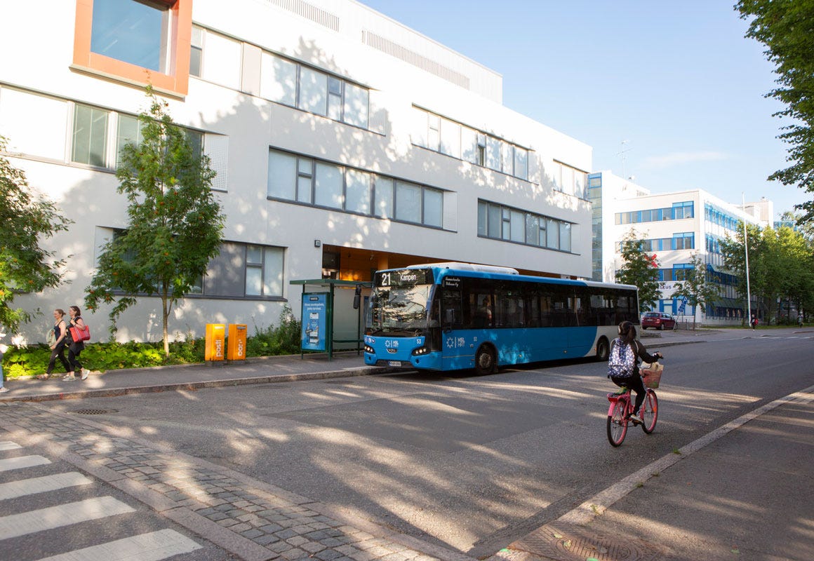 Sininen bussi on pys&auml;kill&auml; Lauttasaaressa. Kadulla kulkee py&ouml;r&auml;ilij&auml; ja jalkak&auml;yt&auml;v&auml;ll&auml; k&auml;velij&ouml;it&auml;.