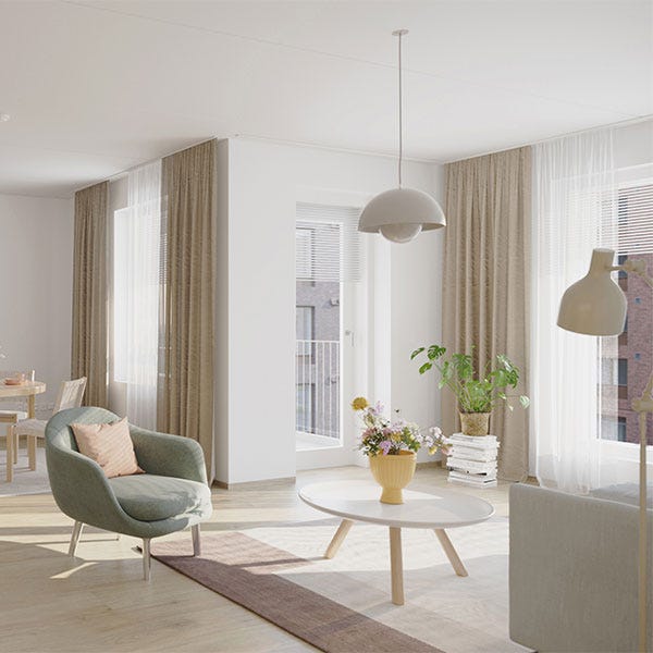 Valoisa olohuone, jossa on pehmeitä sävyjä, vihreä nojatuoli ja vaalea puinen sohvapöytä kukkakimpulla.