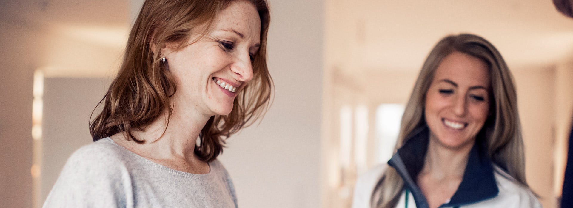 Asiakas hymyilee tyytyväisenä uuden kotinsa avaimet saatuaan. Bonavan edustaja seisoo taustalla iloisena, varmistaen sujuvan ja miellyttävän muuttohetken.